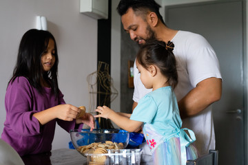 Kids making Kek Batik or Malaysian Triple Chocolate Dessert. Doing the initial steps, crushing the cookies into tiny pieces.
