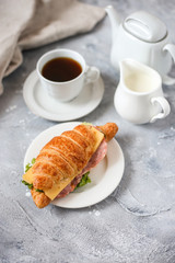 croissant sandwich with ham and salad with cup of coffee