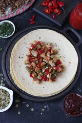 spicy chicken burrito served on a wooden cutting board with tomato juice