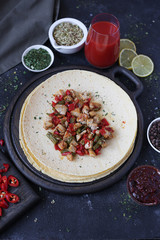 mexican spicy chicken burrito on dark background 
