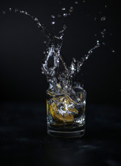 glass of splashing water with lemon 