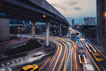 Car lights at evening on the road going to the city. Aerial view of the speed traffic trails on...