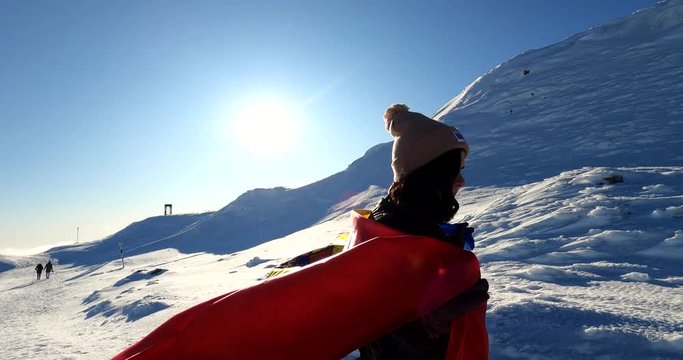 Woman running with a Romanian Flag on top of The Bucegi Mountains in Romania - slow motion shot