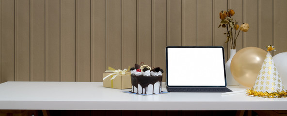 Online birthday party concept with mock-up tablet, cake, present box and decorations