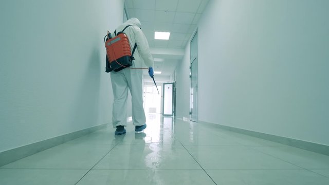 Professional cleaners sanitize floor and walls in building.