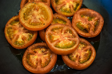 Grilled spicy tomatoes slices on a pan