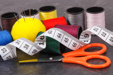 Spools of thread, needle, tape measure and scissors. Accessories for needlework
