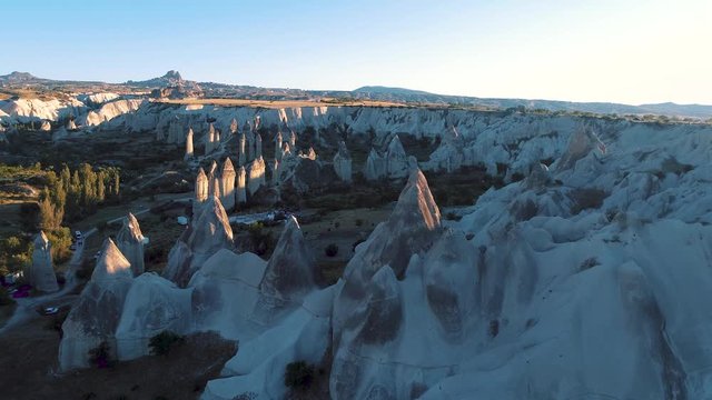 Aerial drone fly through shot of the rock pillars and formations of Goreme / U&ccedil;hisar in Cappadocia, Turkey