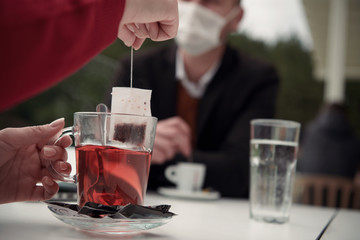 couple with protective medical mask  having coffee break in a restaurant