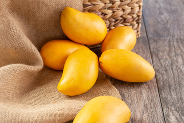 A view of several honey mangoes, in a still life setting.