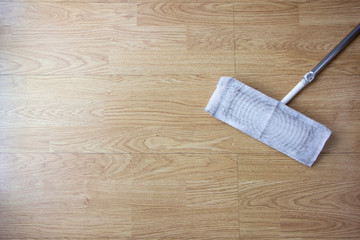 Dirty cleaning mop on wooden laminate floor