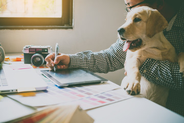 Designers and designers work at home by carrying puppies in their arms.