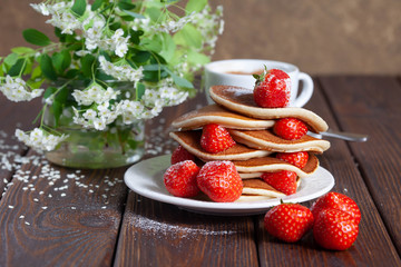Delicious, only baked pancakes with strawberries on a dark surface, homemade cakes