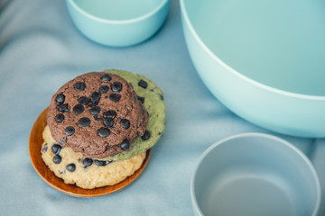 chocolate chunk cookies on a bright blue  with bowl set as background. Food photography style