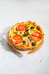 Savory tart with broccoli on white surface, healthy food