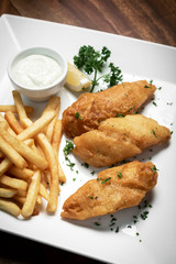 british traditional fish and chips meal on wood table.