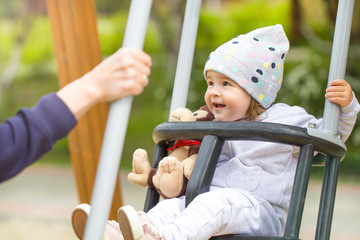 baby child swing in the park walk with mom joy emotion happy summer day