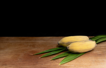 Banana and leaf on wooden background