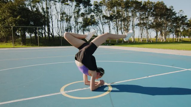 Young Woman Poses in Hollow Back Handstand on Sunny Morning. Wide Shot