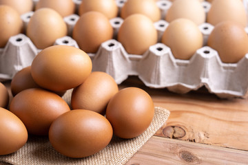Brown Chicken Eggs on wooden background. and carton box