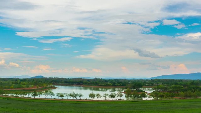 RL Pan time lapse of swamp surrounded by tea plantations with beautiful clouds moving in blue sky. Landscape, agriculture, weather and environment concept.
