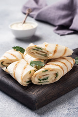 Roll with cheese and herbs. Grilled pita bread with filling. Cucumber radish salad. The concept of a healthy Breakfast.