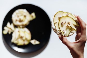 Hand is holding homemade fruit cake for breakfast on the ceramic plate. Top view. selective Focus