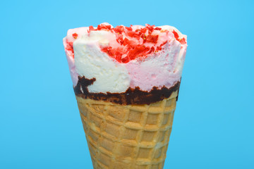 fresh vanilla and strawberry flavor ice cream cone on blue background