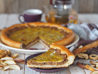 Homemade cake.A large round open pie filled with dried Apple chips on a white wooden table.Delicious dessert for tea.