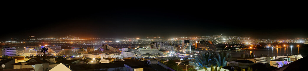 Night panoramic view on beach of the Red Sea in Eilat famous resort and recreation town in Israel and Aqaba cities - Jordan