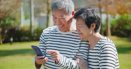 Asian elder couple use mobile