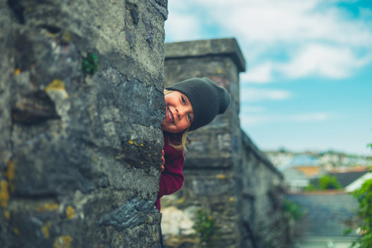 Preschooler hiding behind wall in small town