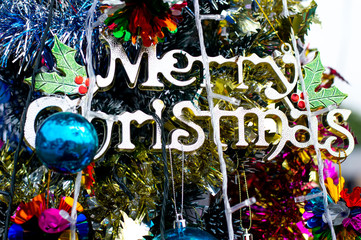 merry chrismas text and ball hanging  on tree