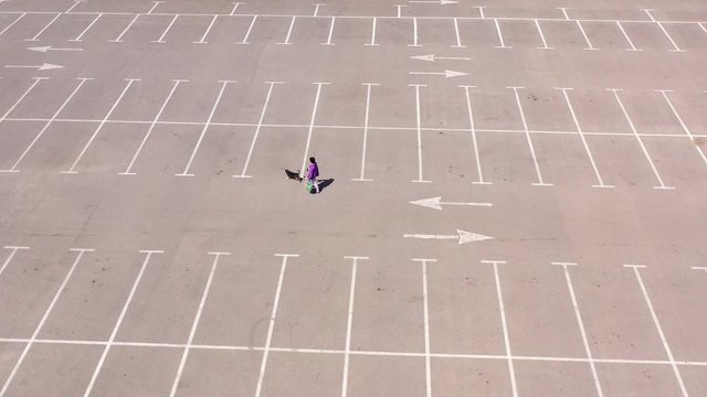 Lady with dog walking in Empty parking lot-Aerial 
Coronavirus lockdown Drone footage Tel aviv/Israel-april,15,2020
