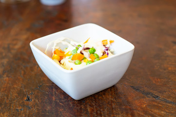 salad and Grains in a white cup on wood table