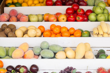 Many fresh fruits for sale displayed on a stand at a local farmers market.