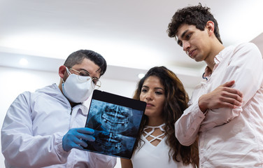Young male doctor showing x-ray to his young patients