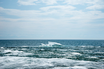 Natural background. Change of seasons.Baikal Lake in May morning.Spring landscape.The view from the rocks in the foreground of a snow-white fragments of ice floes. Northern nature
