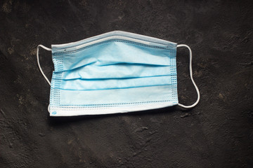 blue medical mask for health protection on a dark textured background