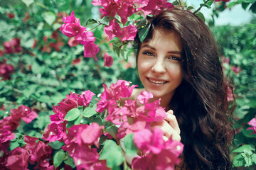 Fototapeta premium Close up portrait girl in the park on a background of pink flowers 