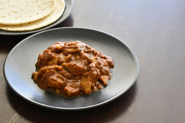 Chicken curry on a plate.  Selective focus.  Copy space is on the right side. 