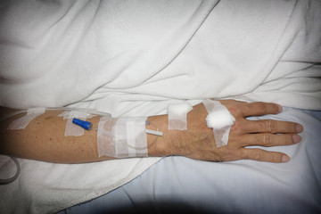 Hand of patient with iv set in hospital