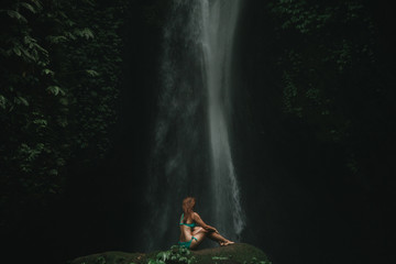 young woman backpacker looking at the waterfall in jungles. Ecotourism concept image travel girl