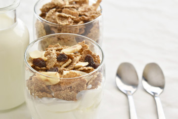 Greek yogurt with fruit and fiber cereal on a glass. The concept of healthy breakfast, healthy food, dietary plan and weight loss program. Selective and soft focus.  Copy space is on the right side.