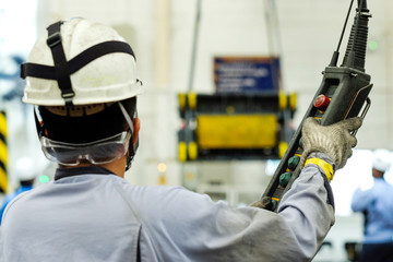 Worker moving crane in the industrial factory