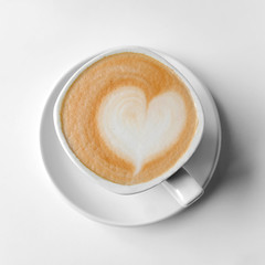 White cup of coffee with a heart made of milk foam.