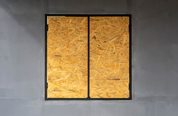 brown plywood window on concrete wall background