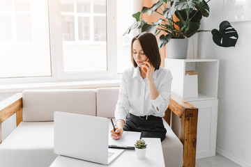 Young businesswoman talking on the phone in office. Business, working from home concept.