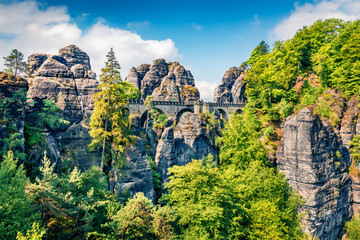 Sunny morning scene of sandstone cliff in Saxon Switzerland National Park with Bastei bridge on background. Colorful spring view of Germany, Saxony, Europe. Traveling concept background..