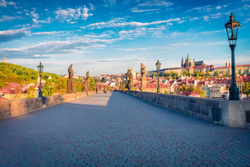 Obraz premium Impressive morning view of Charles Bridge, Prague Castle and St. Vitus cathedral on Vltava river. Bright summer cityscape of Prague, Czech Republic, Europe. Traveling concept background..